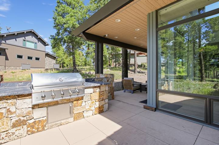 Outdoor kitchen with stone-clad built-in gas grill
