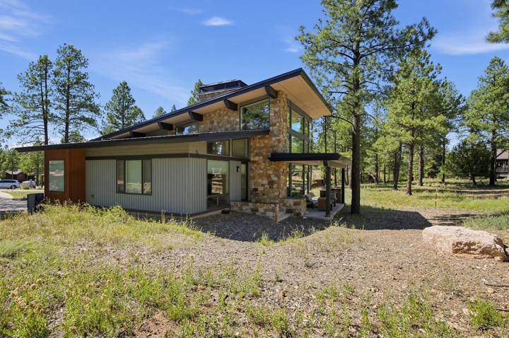 Side view of the home with stone and corten steel siding