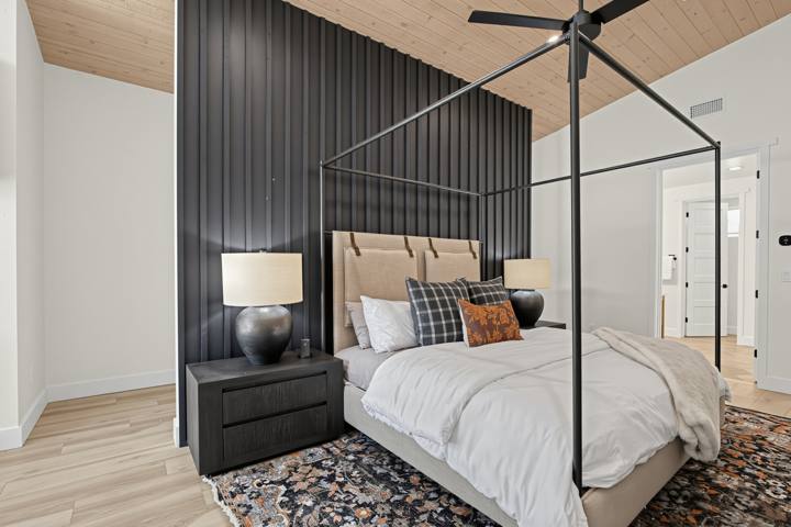 Primary bedroom with black canopy king bed