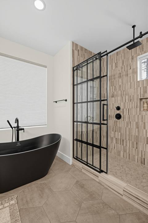 Primary bath with freestanding black tub and walk-in glass shower