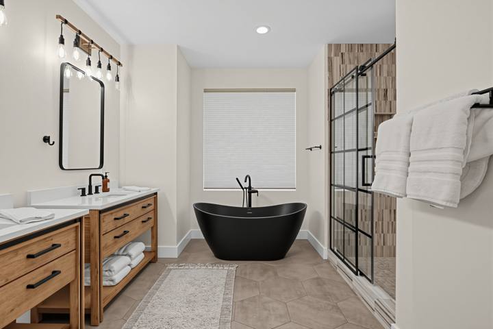 Primary bath with freestanding black soaking tub and glass shower