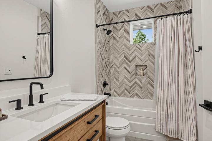 Second suite bath with herringbone tile tub and shower