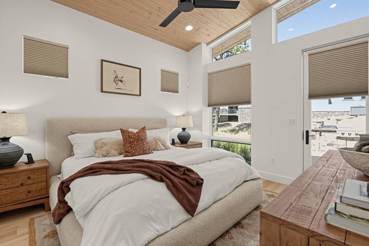 Bedroom with wood ceiling, bench and forest-view windows