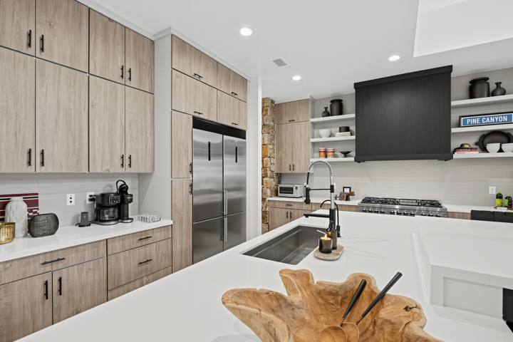 Kitchen with light wood cabinets, stainless appliances and coffee station