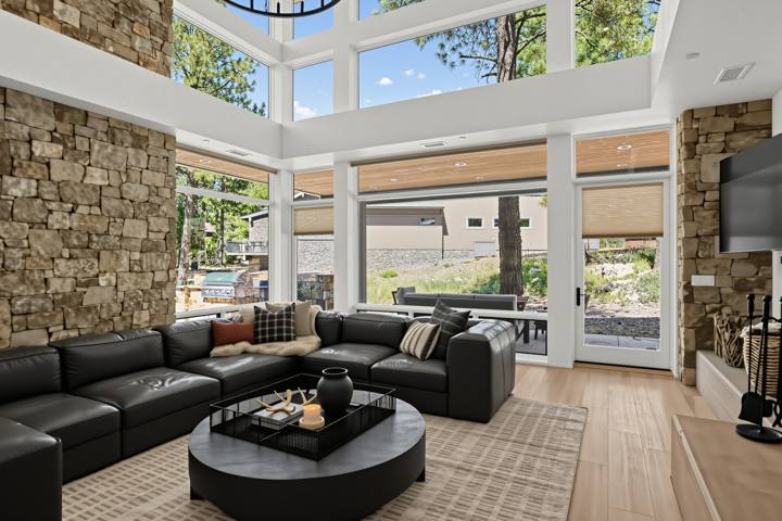 Great room with black leather sectional and floor-to-ceiling windows