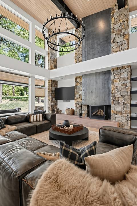 Two-story stone and steel fireplace with iron chandelier