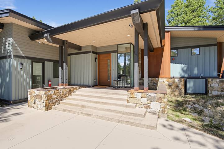 Covered front entry with stone steps and wood door