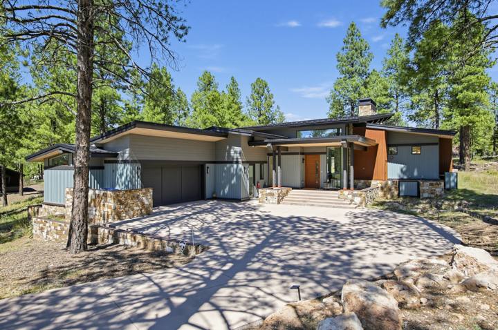 Street view of the house framed by tall pines